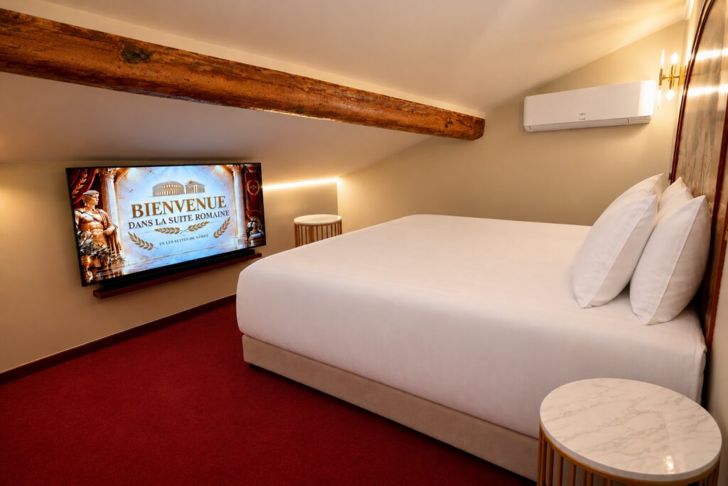 Chambre 1 de La Suite Romaine avec écran de bienvenue et climatisation