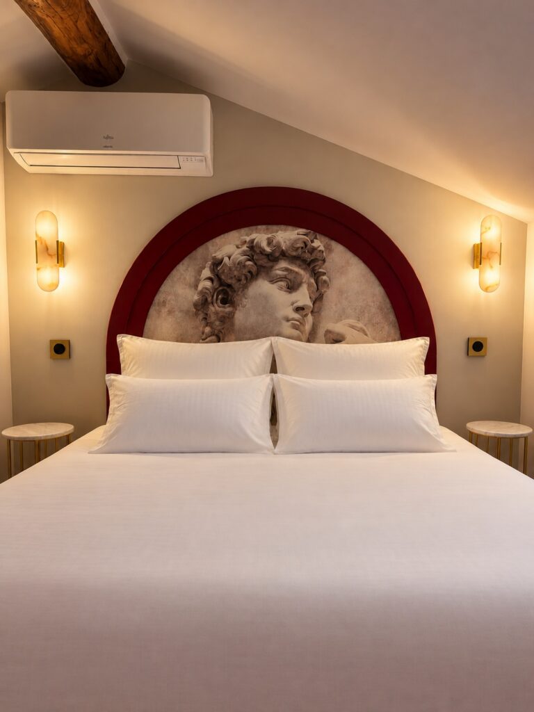 Chambre 2 de La Suite Romaine : tête de lit au buste de David et appliques en albâtre