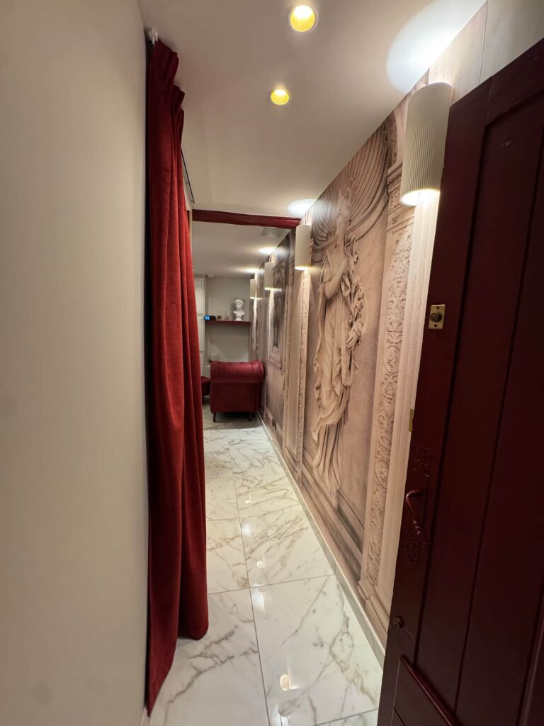 La Suite Romaine à Nîmes : couloir et rideaux rouges
